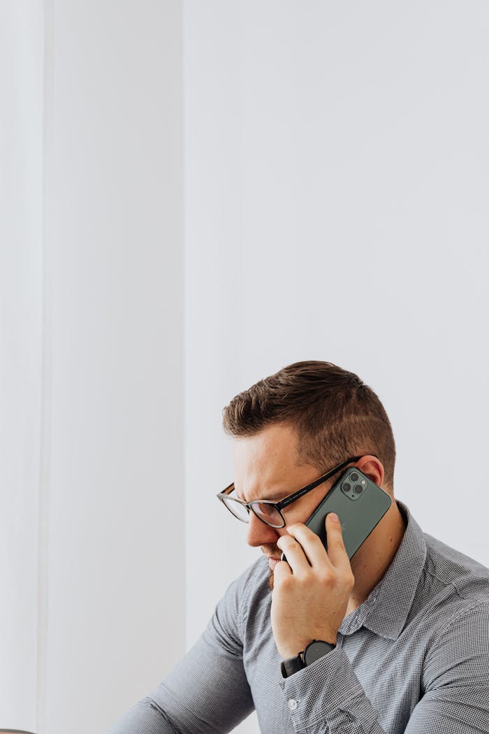 Pensive man in office on phone call, focused and professional.